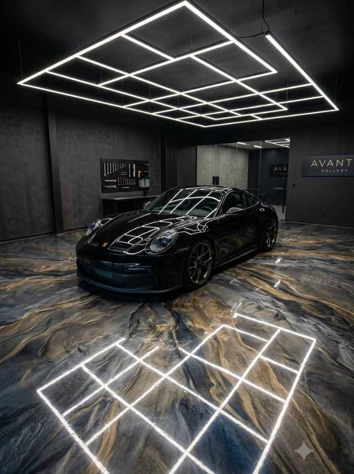 Luxury garage featuring a gallery-grade 3D metallic marbling epoxy floor with subtle silver and charcoal veining under LED grid lighting.
