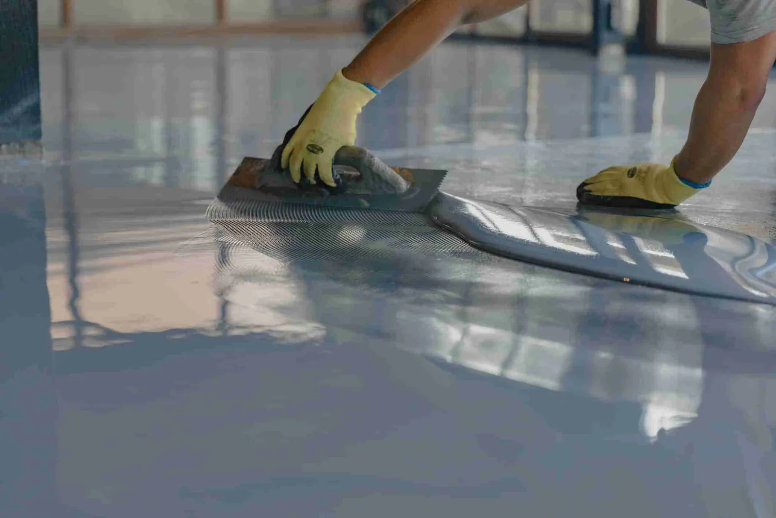 Epoxy floor coating supplies including silica sand, aluminum oxide grit, roller, and mixing tools